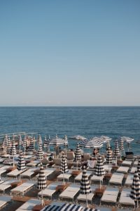 A beach filled with lots of lawn chairs and umbrellas